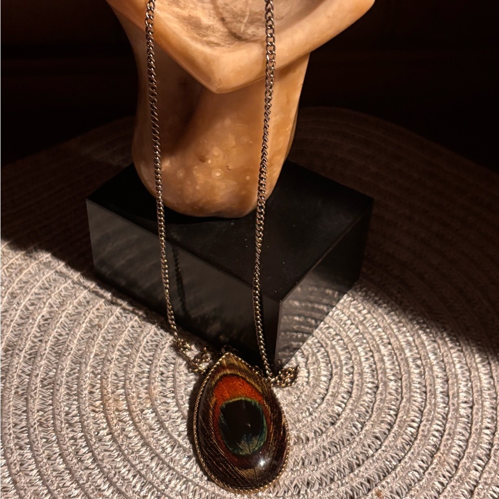 Necklace with peacock feather design pendant.